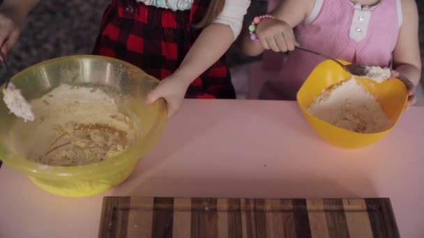 Vista dall'alto di due ragazze che mescolano la pasta in boccia a cucina — Video Stock