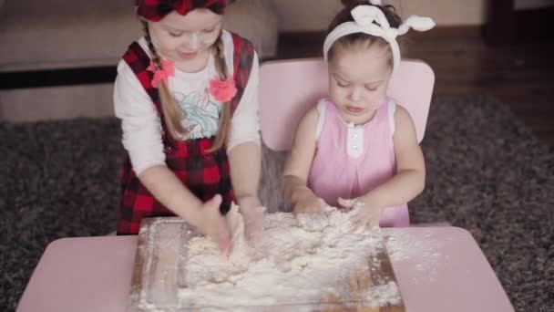 Vista dall'alto di due sorelle che giocano con la farina in cucina — Video Stock