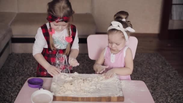 Вид сверху на двух сестер, играющих с мукой на кухне — стоковое видео