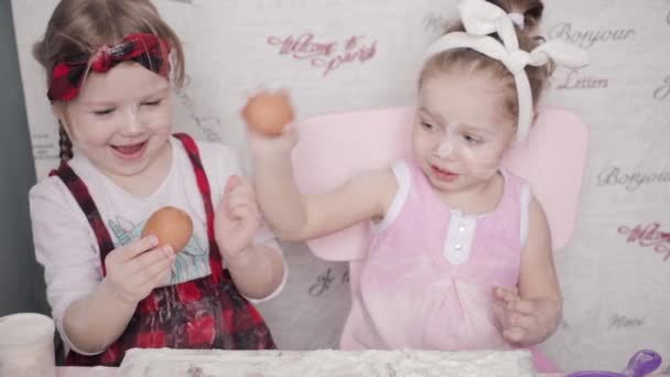 Visa från ovan av två systrar spelar med mjöl på kök — Stockvideo