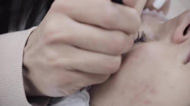 Profesyonel kirpik uzatma yordamda yakın çekim.