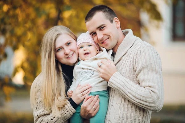 Jonge gelukkige familie glimlachend op camera en permanent samen. — Stockfoto