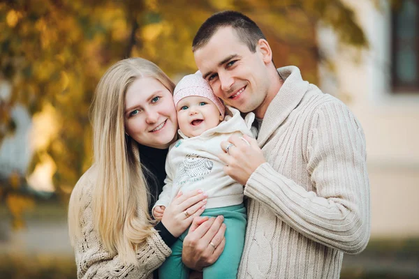 Jovem família feliz sorrindo para a câmera e de pé juntos . — Fotografia de Stock