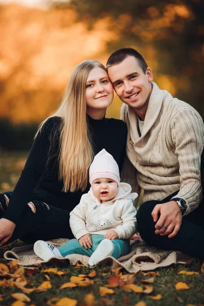 Jonge gelukkige familie glimlachend op camera en permanent samen. — Stockfoto