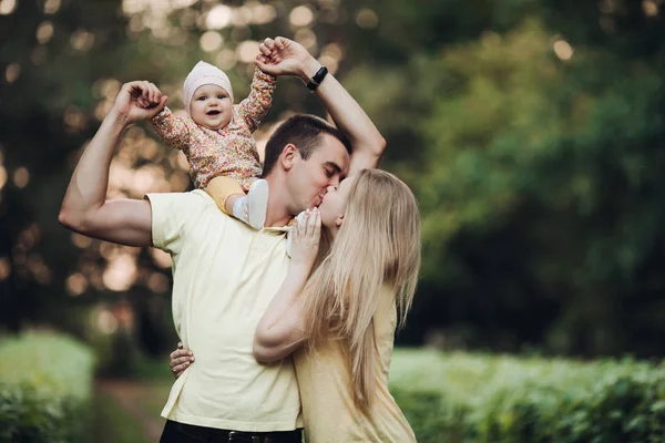 Portret van mooie jonge gezin samen buiten zitten. — Stockfoto