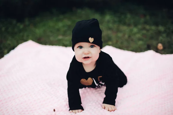 Klein kind met schattige ogen liggend op roze deken op grond. — Stockfoto