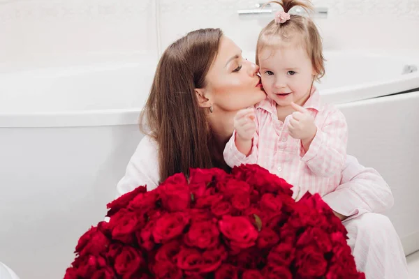 Hermosa madre posando con chica y gran ramo de rosas — Foto de Stock