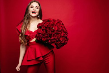 Kırmızı gül buketi tutmak içinde muhteşem kadın