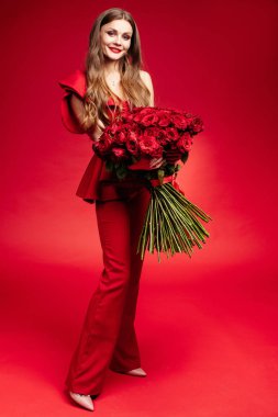 Mutlu genç esmer Kırmızı elbiseli büyük kırmızı gül demet holding.