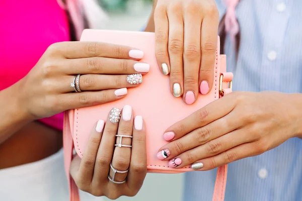 Close up van tas met meisjes handen met manicure overheen. — Stockfoto