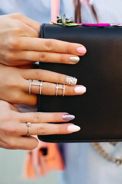 Mädchen zeigen ihre stylische Maniküre und halten ihre Finger auf schwarzer Handtasche. — Stockfoto