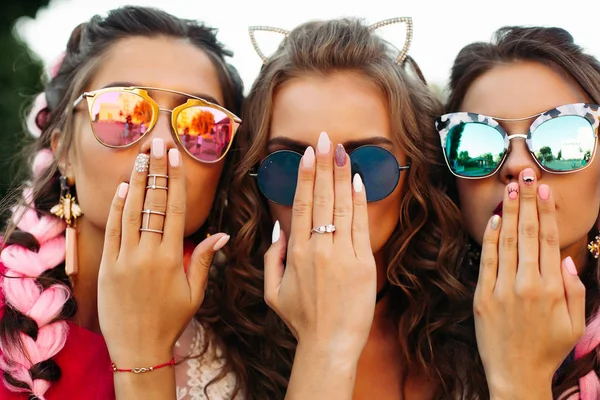 Close up de três meninas vestindo em óculos de sol escondendo rosto por mãos . — Fotografia de Stock