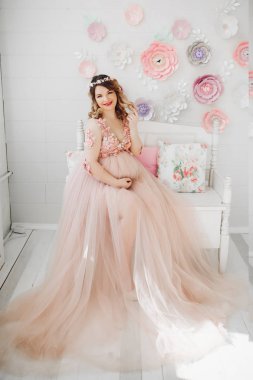 Zarif gelecekte anne uzun toz elbiseyle poz.