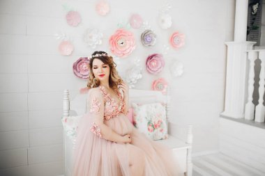 Zarif gelecekte anne uzun toz elbiseyle poz.