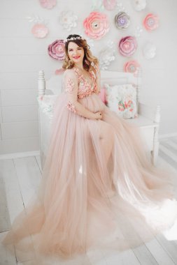 Zarif gelecekte anne uzun toz elbiseyle poz.