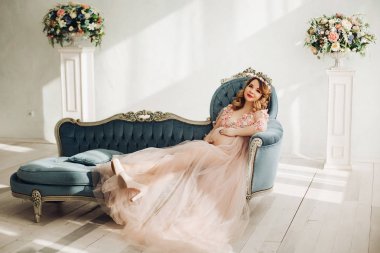 Zarif gelecekte anne uzun toz elbiseyle poz.