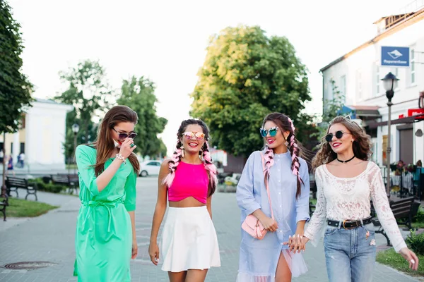 Gelukkig modieuze vrouwen in kleurrijke kleding lopen op straat. — Stockfoto