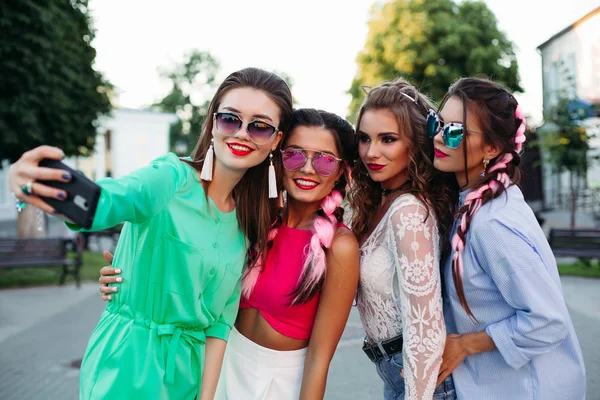 Mujeres sonrientes posando y virando autorretrato en teléfonos inteligentes . —  Fotos de Stock