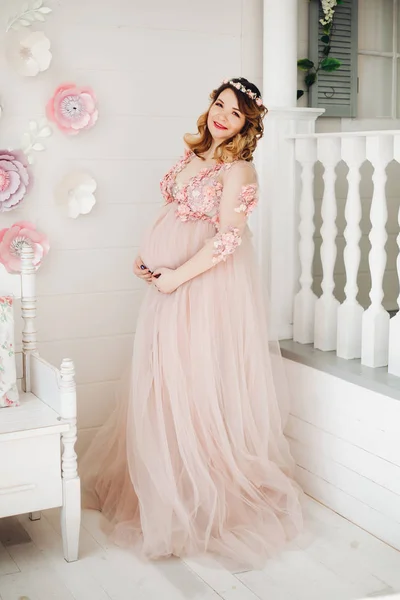 長い粉ドレスでポーズをとってエレガントな将来の母親. — ストック写真
