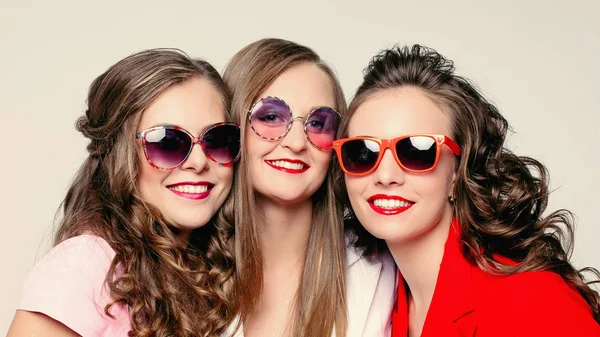 Schöne glückliche Damen in modischen Sonnenbrillen und Jacken. — Stockfoto