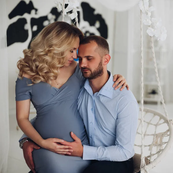 Casal lindo de mulher grávida e seu marido abraçando . — Fotografia de Stock