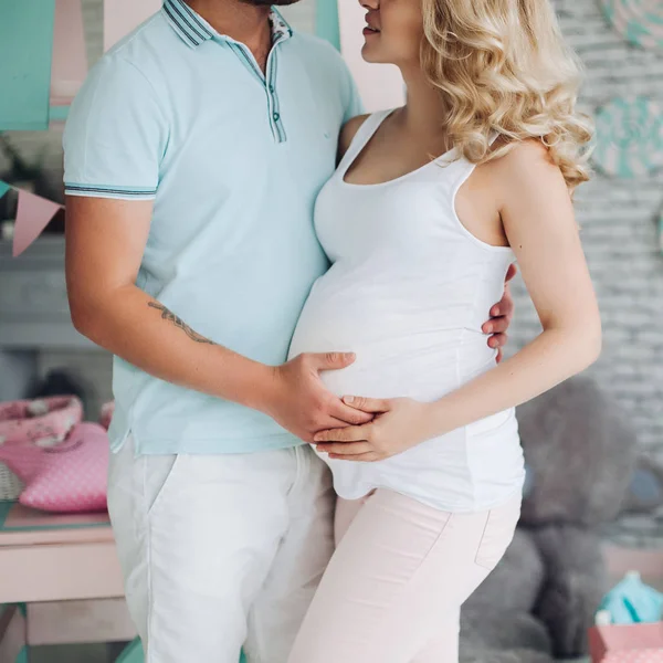 Pragnancy jonge familie staande onder speelgoed. — Stockfoto