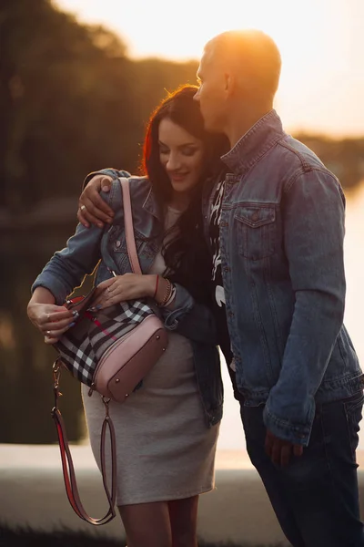 Padres encantadores de pie cerca del lago y posando juntos —  Fotos de Stock