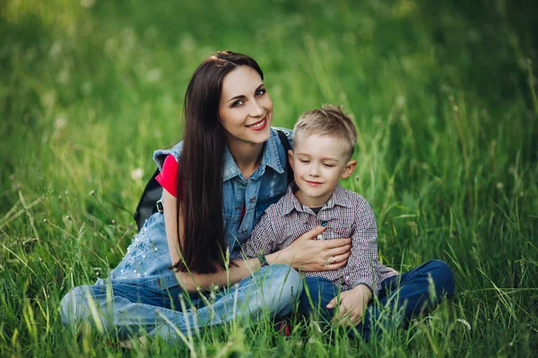 Portret van gelukkig vrolijke moeder en zoon poseren in de zomertuin. — Stockfoto