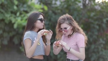 İki güzel şık kızlar hamburger yemek.