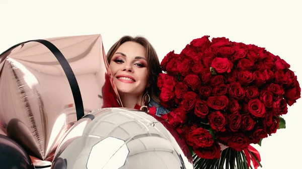 Ragazza abbastanza positiva con make up tenendo bouquet di rose rosse e palloncini d'aria . — Foto Stock