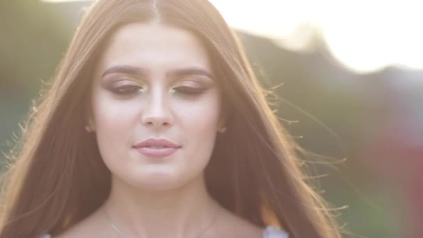 Hübsche lächelnde Brünette mit Make-up im Sonnenlicht. — Stockvideo