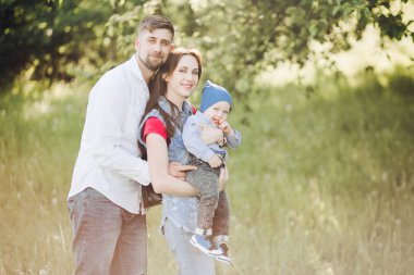 Esmer koca karısını küçük oğlu tutarak ve sarılma kadın öpüşme.