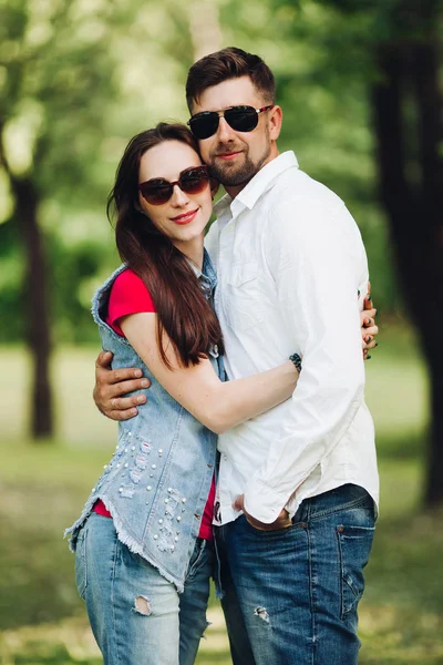 Ritratto di giovane coppia felice innamorata, sorridente e abbracciata in giardino . — Foto Stock