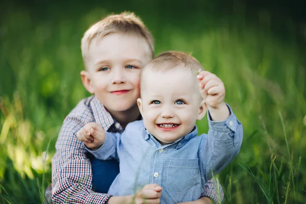 两个小弟弟在公园里拥抱和看镜头. — 图库照片