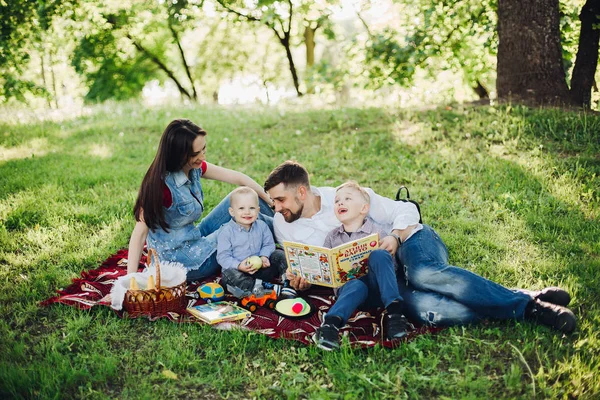 Pozitivní rodina odpočívá v letním parku společně s dětmi. — Stock fotografie