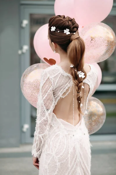 Slim stunning brunette with flowers in her hair and white dress. — Stock Photo, Image