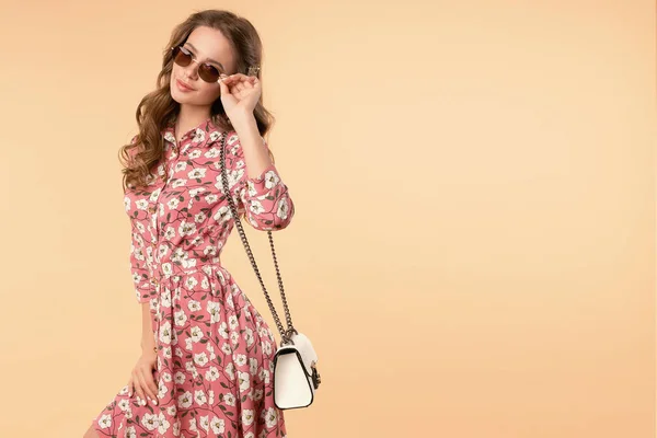 Menina doce e charmoso em vestido de verão bonito com bolsa e óculos de sol . — Fotografia de Stock