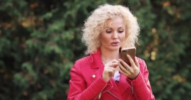 Telefon bakarak sarışın, mesaj almak ve gülüyor