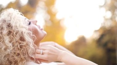 Kıvırcık saçlı dokunuyor, sonbahar Park'ta yürüyordunuz güzel sarışın kadın.