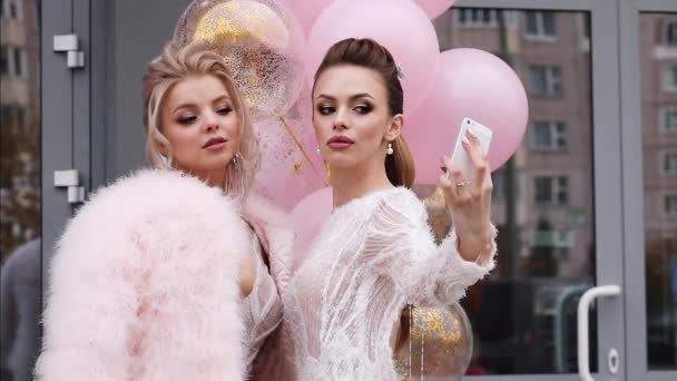 Zwei schöne und sexy Freundinnen machen Selfies mit Luftballons. — Stockvideo