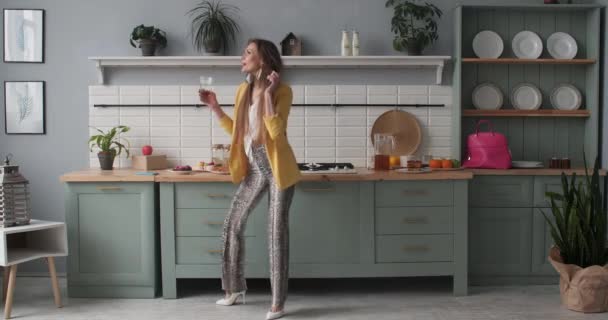 Ευτυχισμένο νεαρό κορίτσι με μοντέρνα ρούχα που χορεύουν στην κουζίνα. — Αρχείο Βίντεο