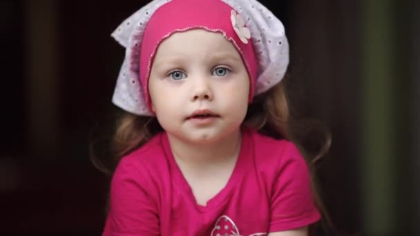 Pequena criança doce em rosa sentada com boca amplamente aberta . — Vídeo de Stock