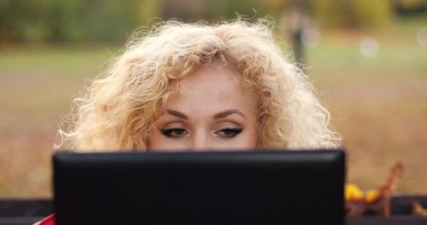 Fiatal lány göndör hajú mögé bújva laptop és mosolygós. — Stock videók
