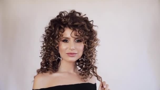 Sexy young woman with curly hair looking at camera. — Stock Video