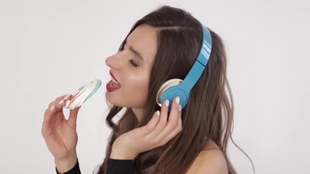 Щаслива молода дівчина у великих навушниках слухає музику . — стокове відео