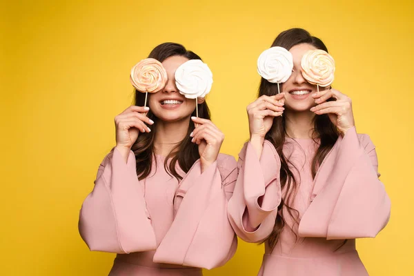 Gêmeos encantadores fechando os olhos com pirulitos e posando — Fotografia de Stock