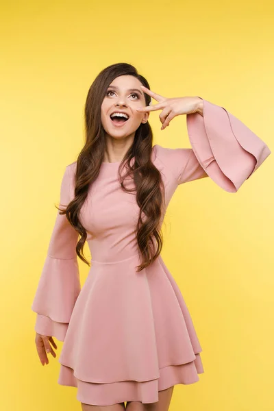 화려한 행복 한 소녀 와 헤어 스타일 에 핑크 드레스 와 ok 기호. — 스톡 사진