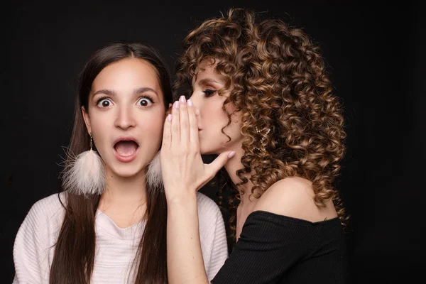 Shocked brunette posing while friend whispering secret — Stock Photo, Image