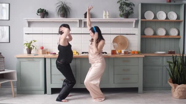 Chicas felices en pijama divirtiéndose en la cocina por la mañana . — Vídeos de Stock