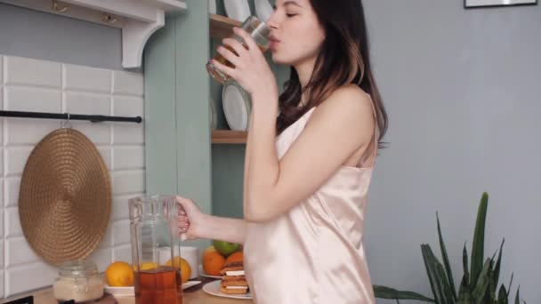 Jovem usando pijama bebendo suco fresco de manhã — Vídeo de Stock